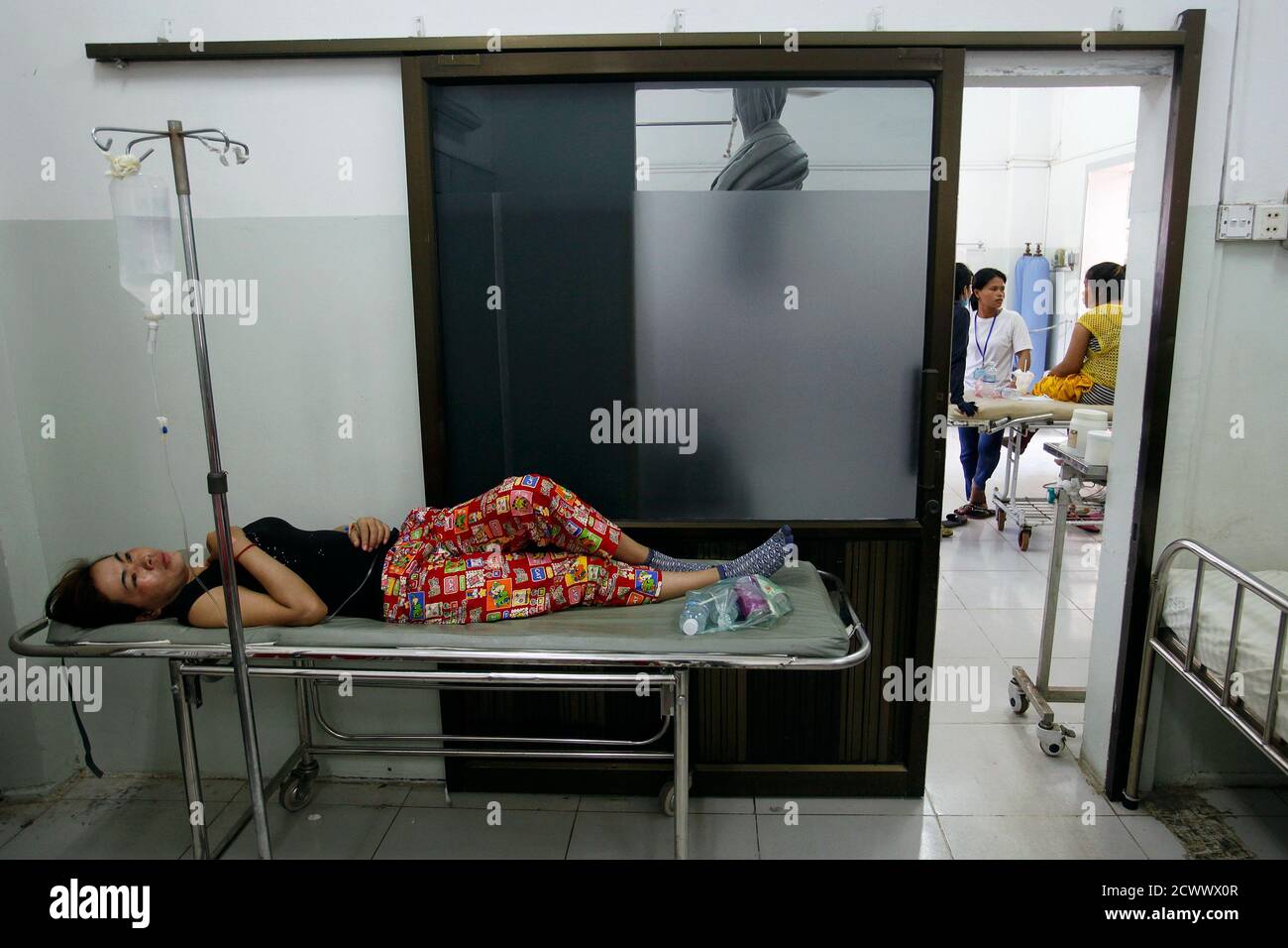 A garment worker recovers at a hospital after fainting at a factory in  Phnom Penh April 3, 2014. Scores of garment workers have fallen sick this  week at factories in Cambodia including