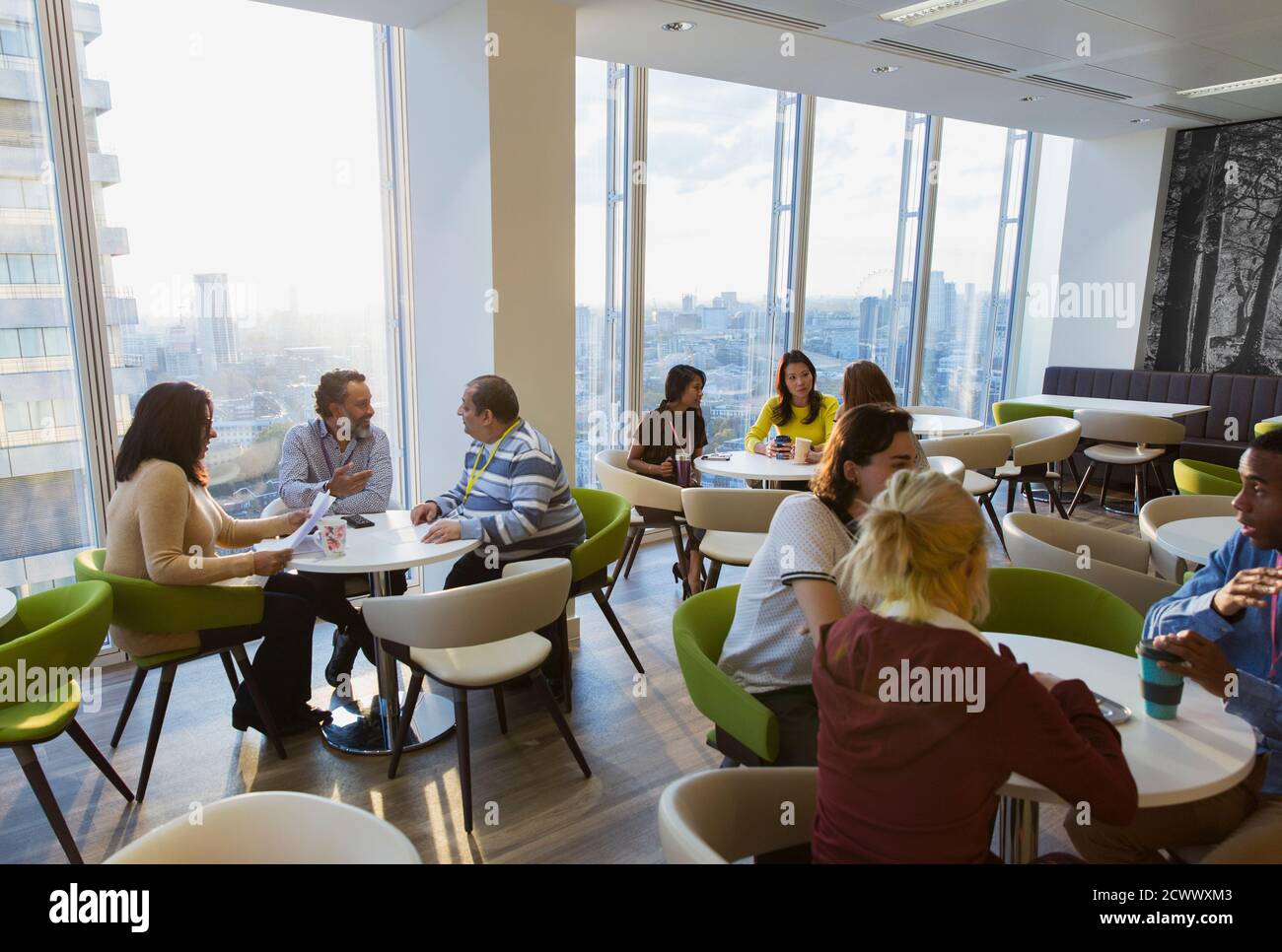 Business people meeting and eating lunch in highrise cafeteria Stock Photo