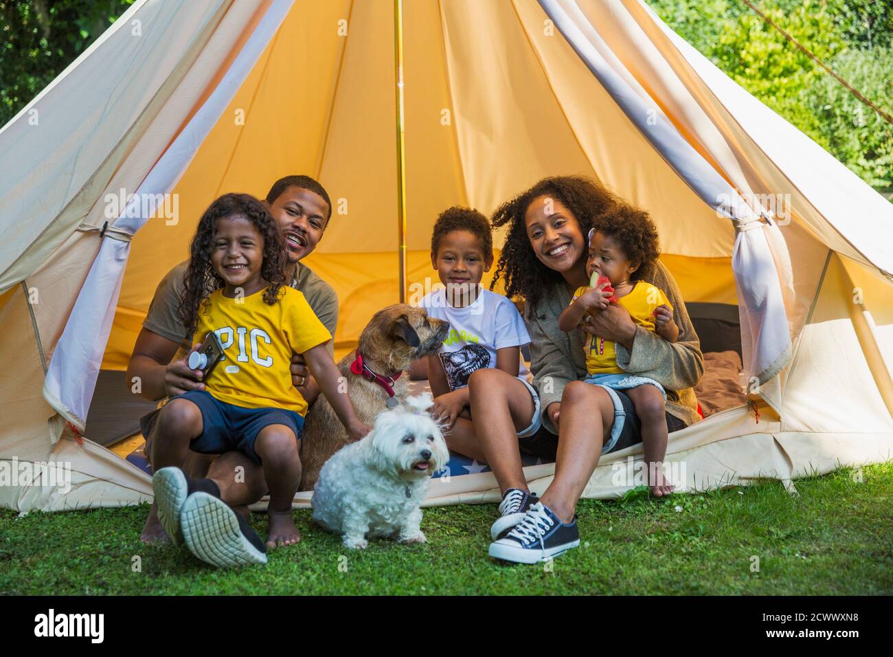 Portrait happy family with dogs in camping tent Stock Photo