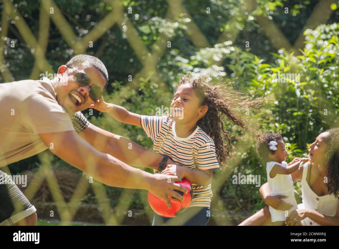 Playful family playing soccer in sunny summer backyard Stock Photo - Alamy
