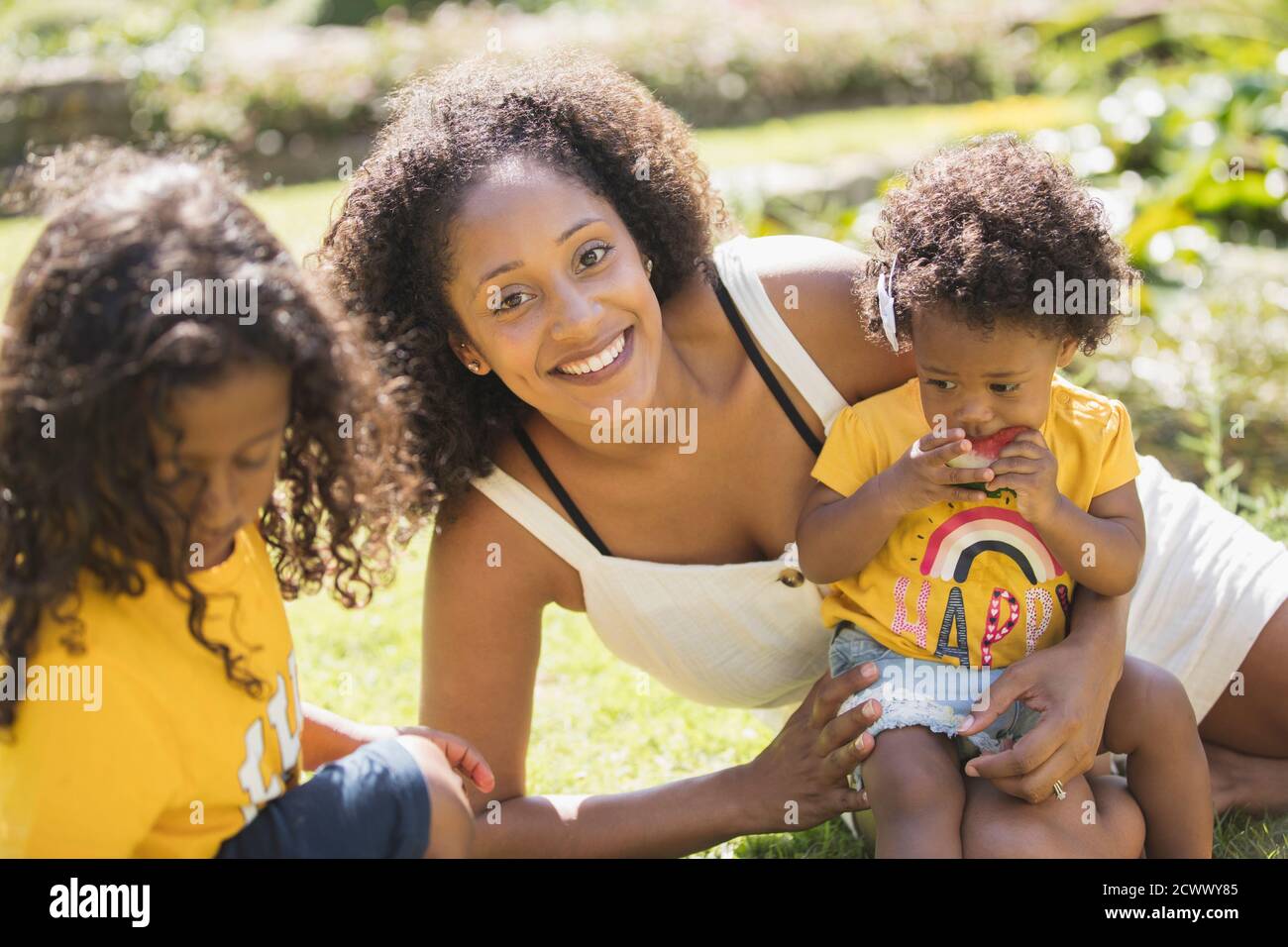Portrait happy mother and children in sunny summer yard Stock Photo