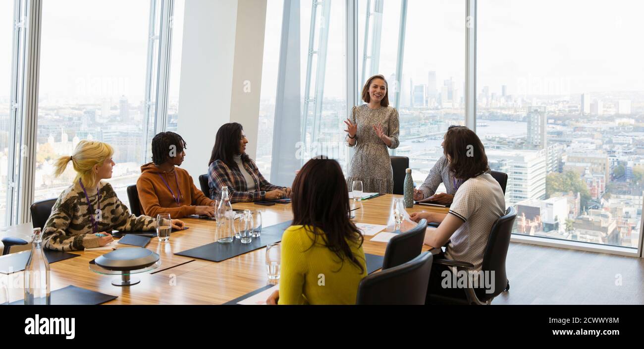 Businesswoman leading conference room meeting in highrise office Stock Photo
