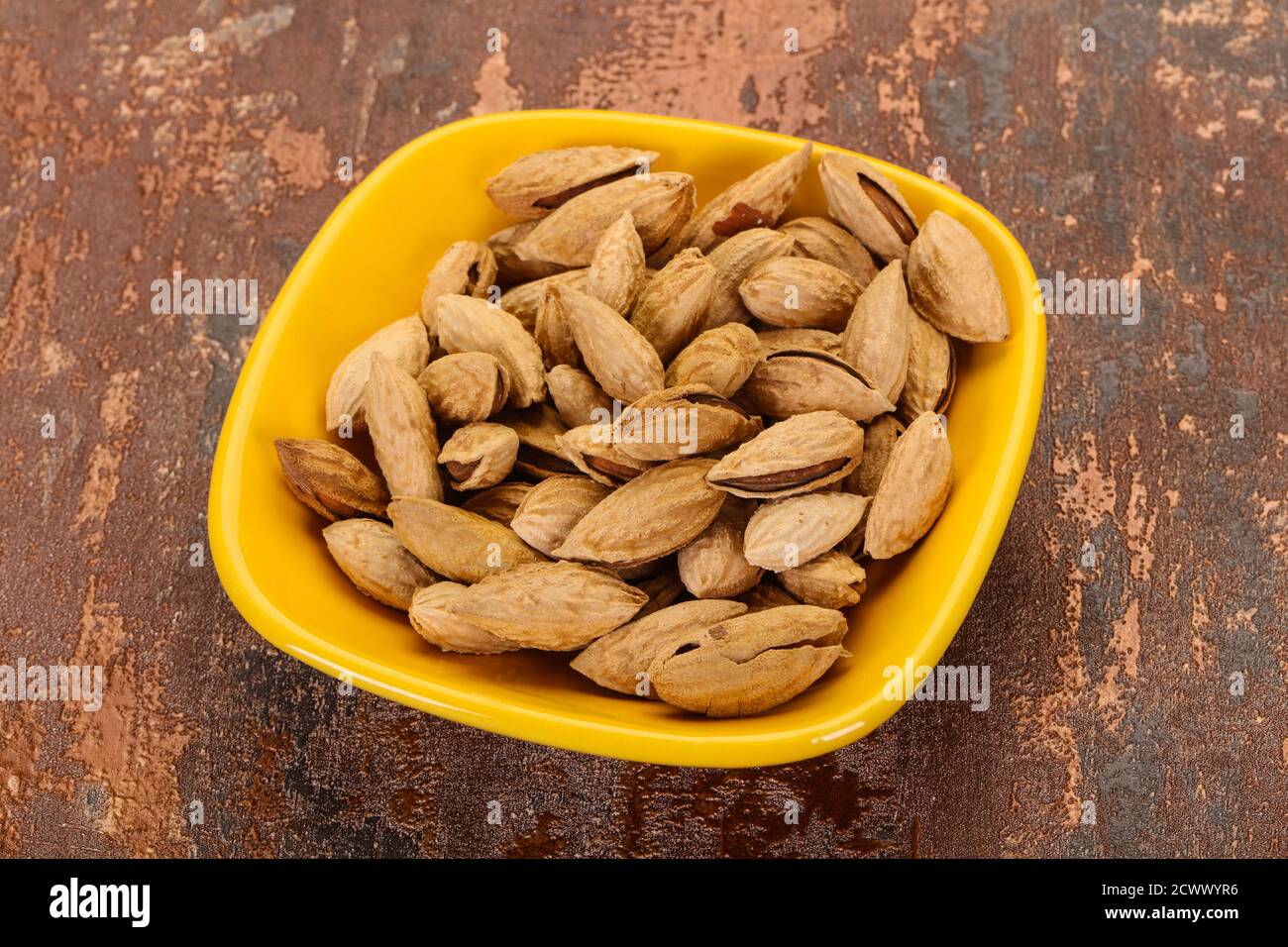 Unpeeled Almonds nuts heap in the bowl Stock Photo - Alamy