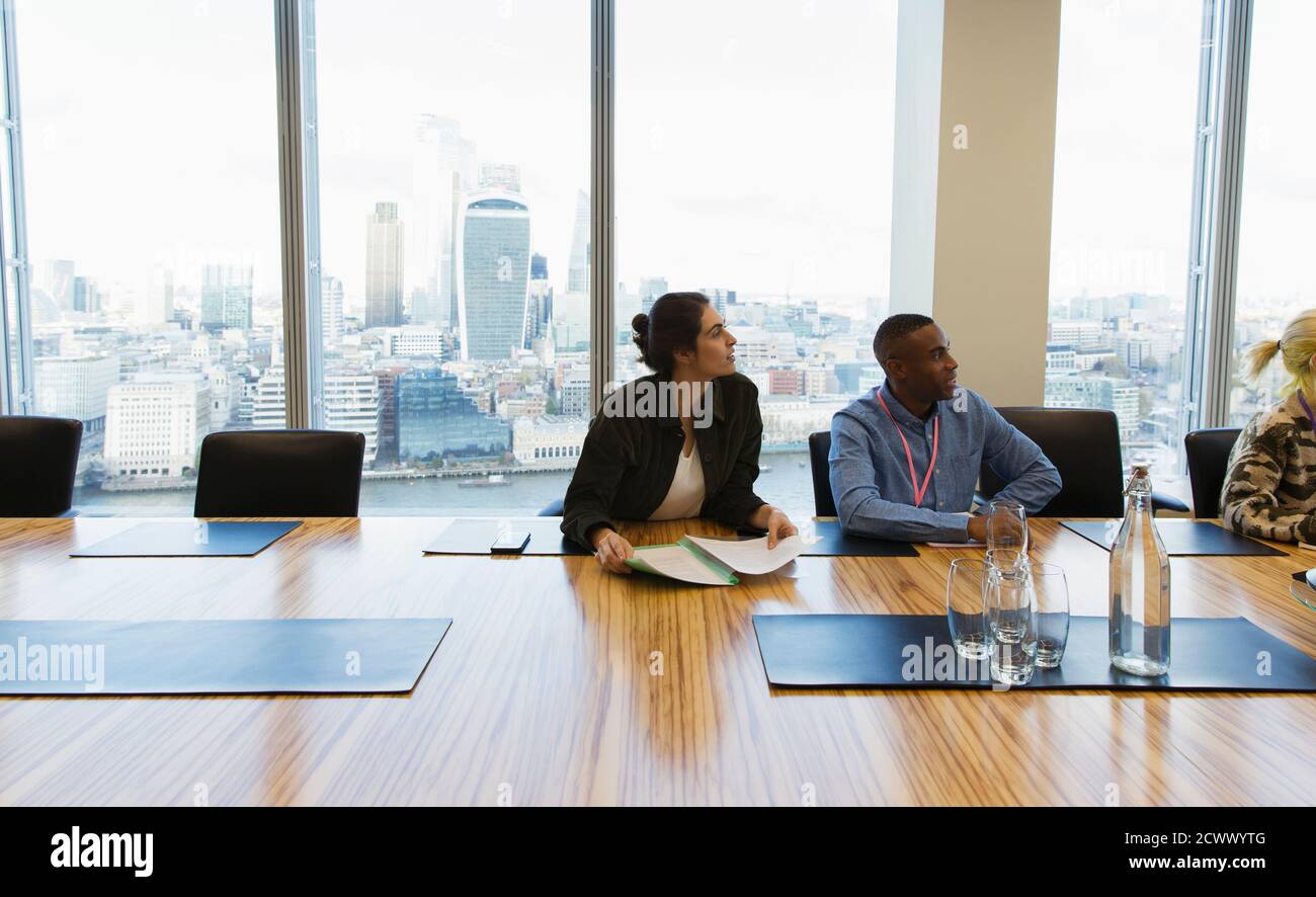 Business people listening in highrise conference room meeting Stock Photo