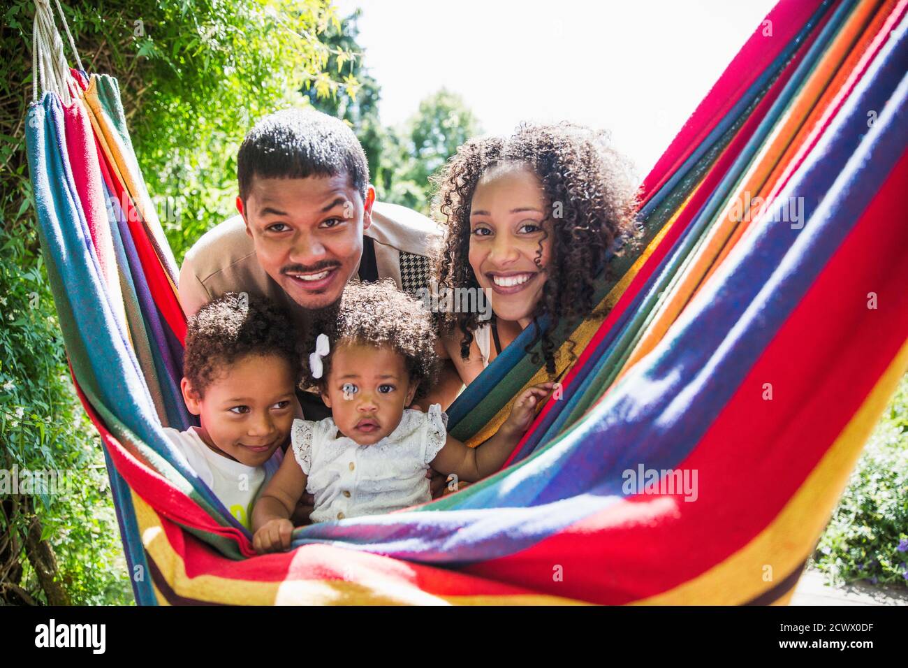 Portrait happy family at sunny summer hammock Stock Photo