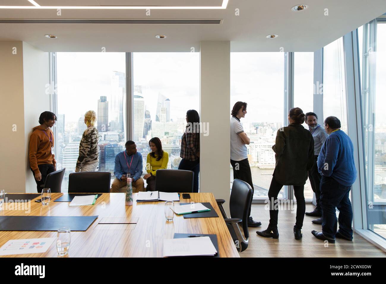 Business people talking at highrise conference room windows Stock Photo