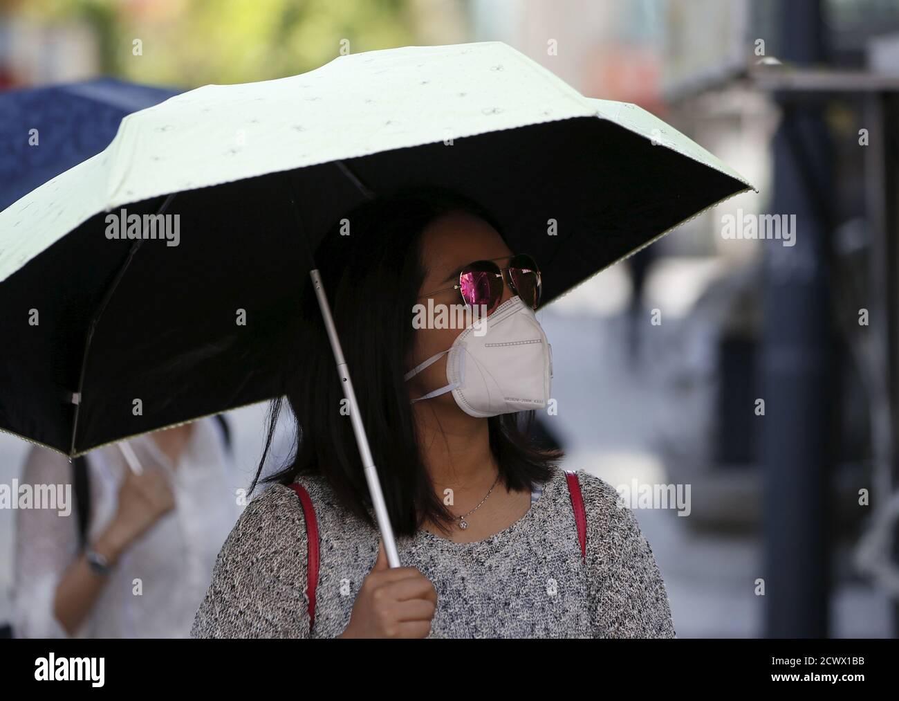 A tourist wearing a mask to prevent contracting Middle East Respiratory Syndrome (MERS), walks at Myeongdong shopping district in central Seoul, South Korea June 3, 2015. South Korea confirmed five more cases of the Middle East Respiratory Syndrome (MERS) virus, the health ministry said early on Wednesday, bringing to 30 the total number of cases in the country of the often-deadly illness.  REUTERS/Kim Hong-Ji      TPX IMAGES OF THE DAY Stock Photo
