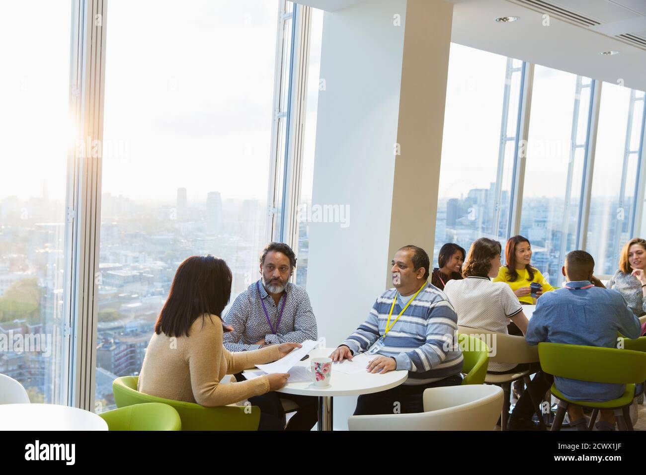 Business people meeting in sunny highrise office cafeteria Stock Photo