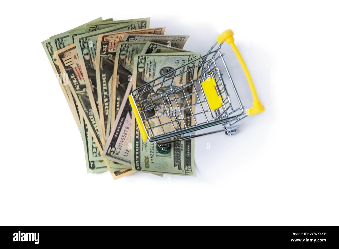 small shopping trolley above dollars money cash. Isolated Stock Photo