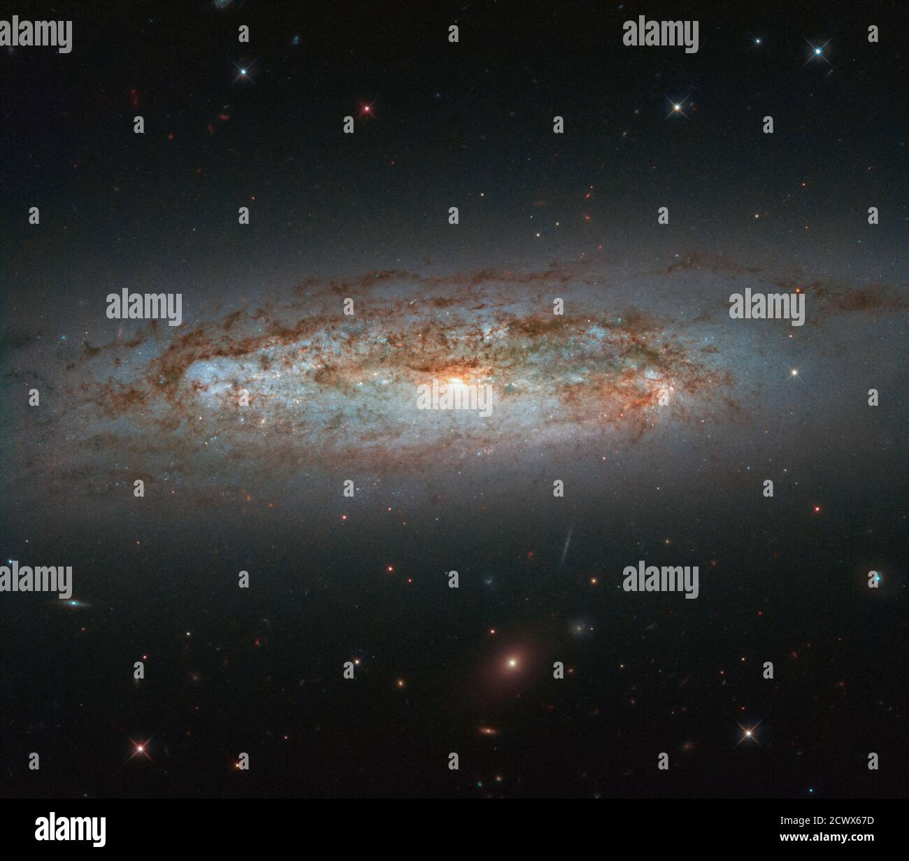 Hubble Views Galaxy’s Dazzling Display NGC 3175 is located around 50 million light-years away in the constellation of Antlia (the Air Pump). The galaxy can be seen slicing across the frame in this image from the NASA/ESA Hubble Space Telescope. Its mix of bright patches of glowing gas, dark lanes of dust, bright core, and whirling, pinwheeling arms come together to paint a beautiful celestial scene. Stock Photo