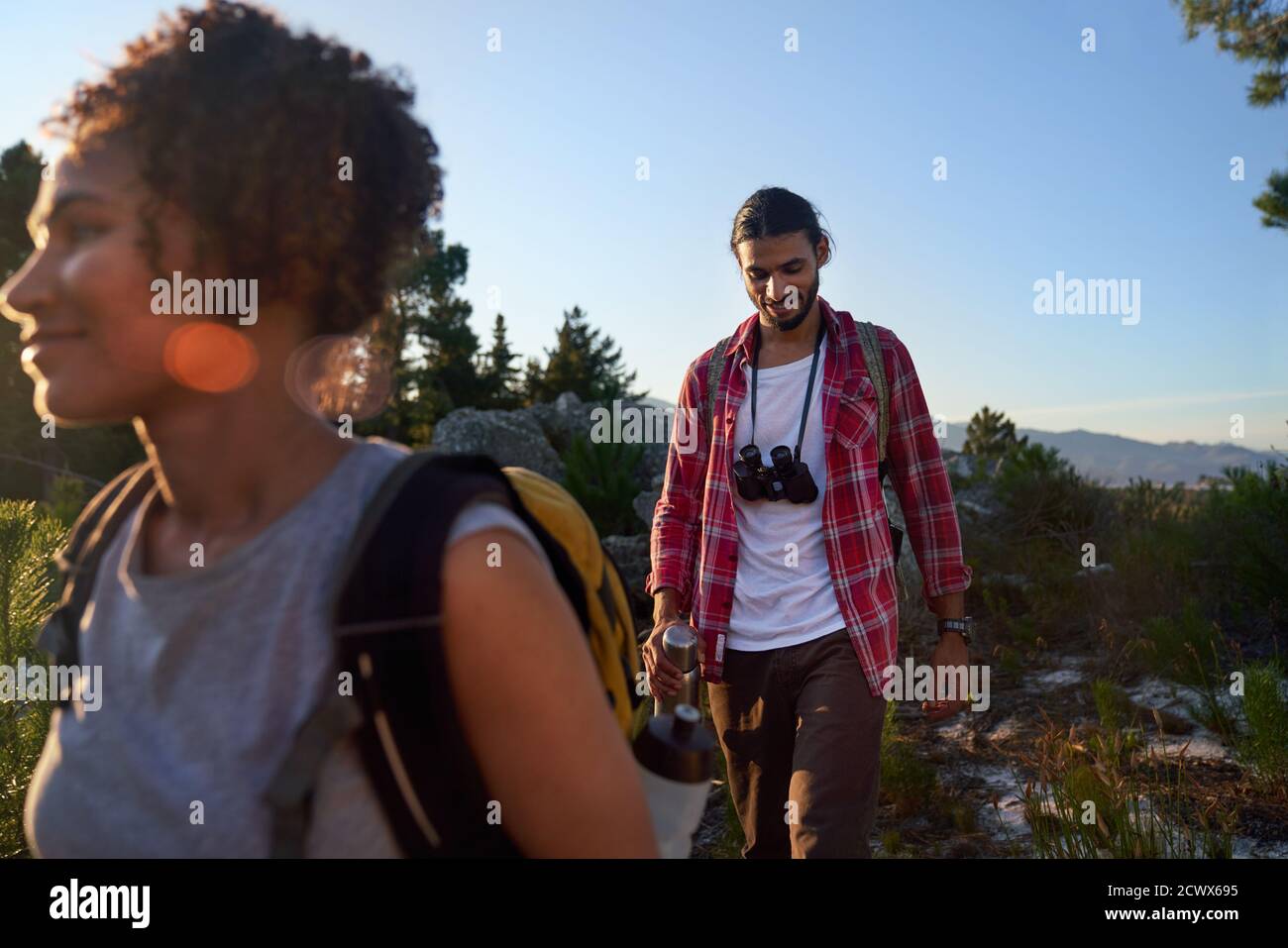 Young couple with binoculars hiking in sunny nature Stock Photo