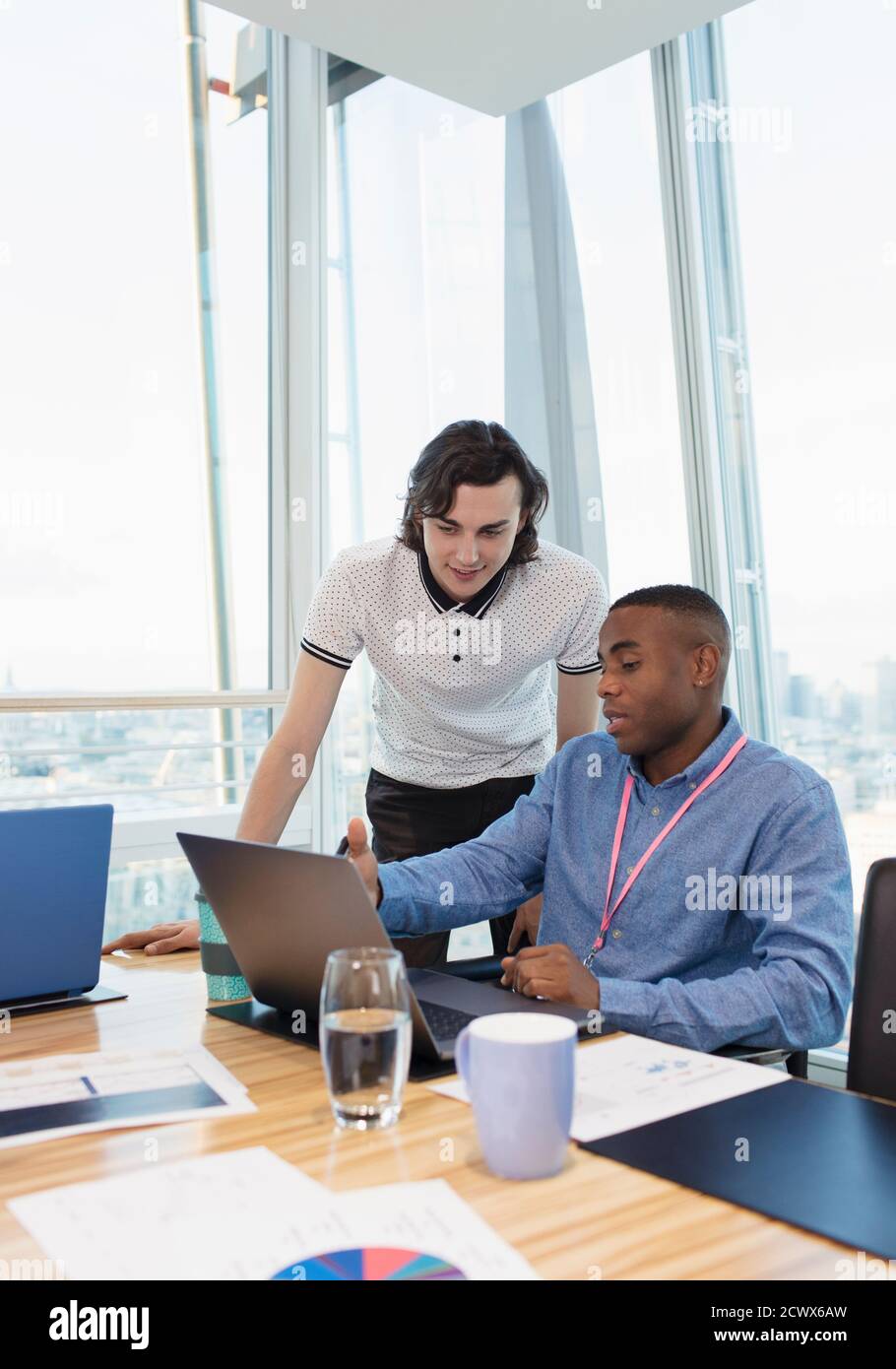 Businessmen working at laptop in conference room Stock Photo
