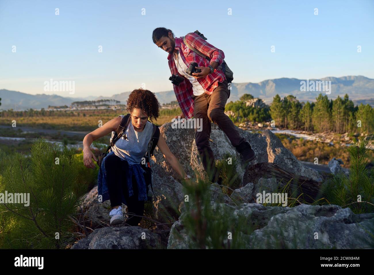 Young couple hiking on rocks in nature Stock Photo