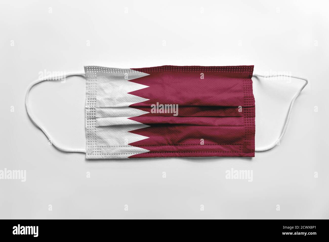 Face mask with Qatar flag printed, on white background, isolated. Covid