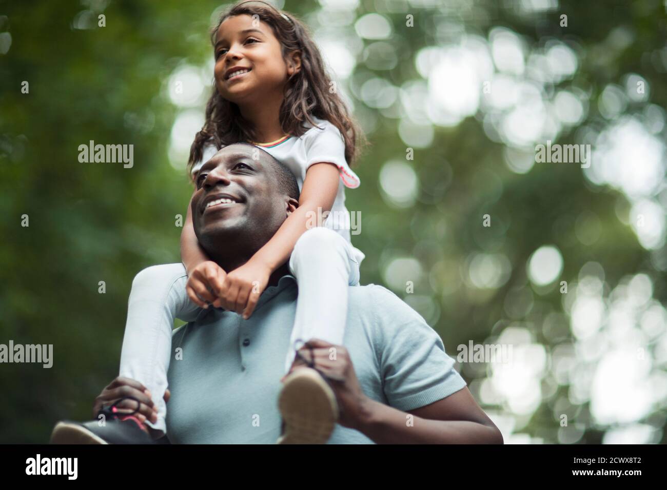 Happy father carrying daughter on shoulders Stock Photo