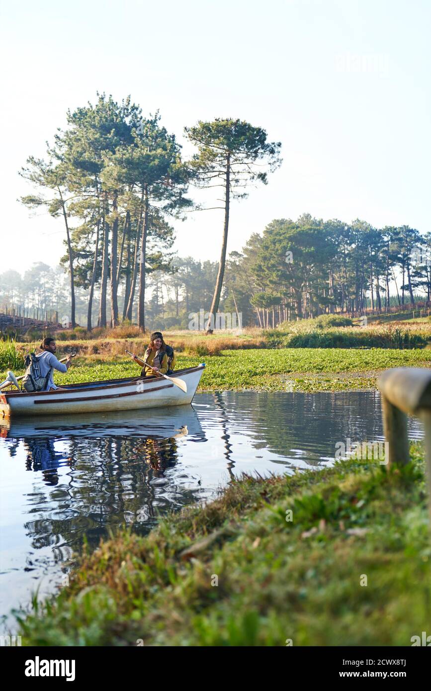Young couple in rowboat on sunny tranquil pond Stock Photo