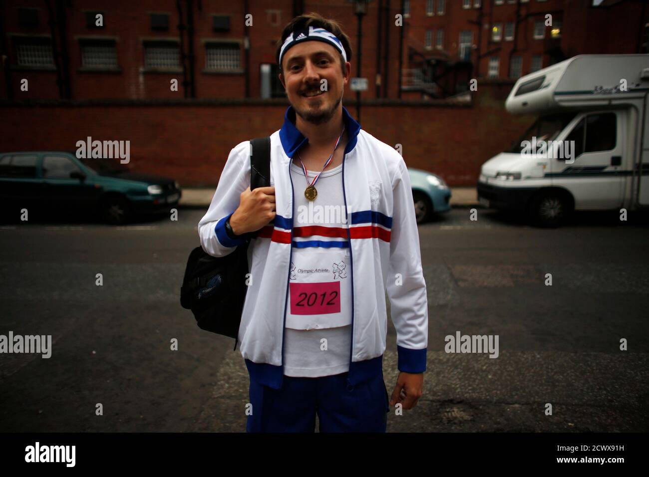 A man poses for a picture with his makeshift Olympic outfit on his way to a party during the night of the opening ceremony of London 2012 Olympic Games in London July 27, 2012. REUTERS/Mark Blinch (BRITAIN - Tags: SPORT OLYMPICS) Stock Photo