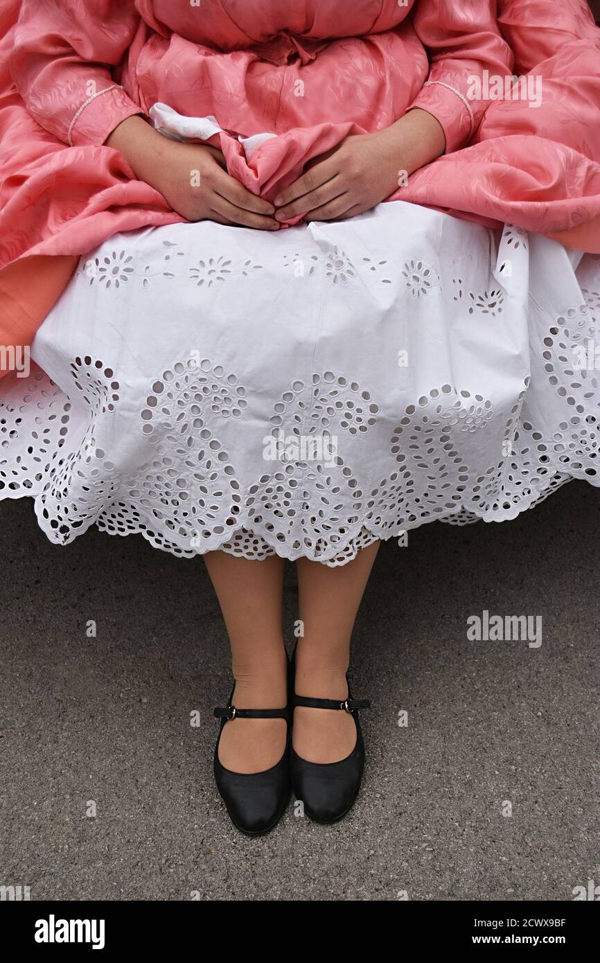 Vertical shot of a female wearing an old petticoat hand-embroidered cotton under a pink dress Stock Photo