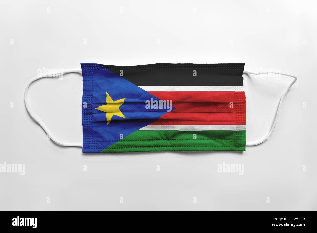 Face mask with South Sudan flag printed, on white background, isolated. Covid-19 concept. Stock Photo