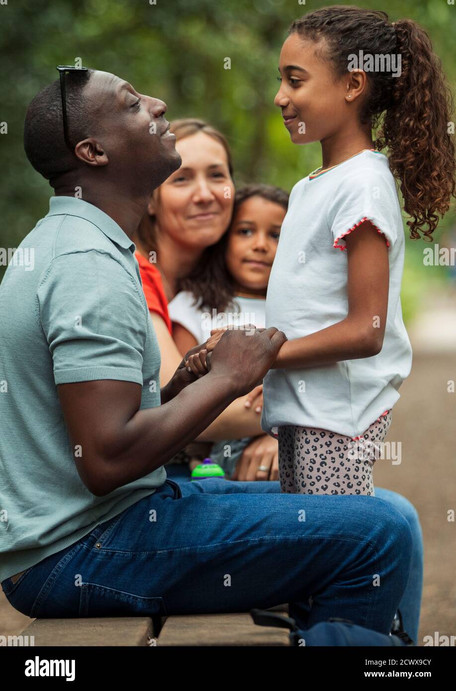 Happy family talking on park bench Stock Photo