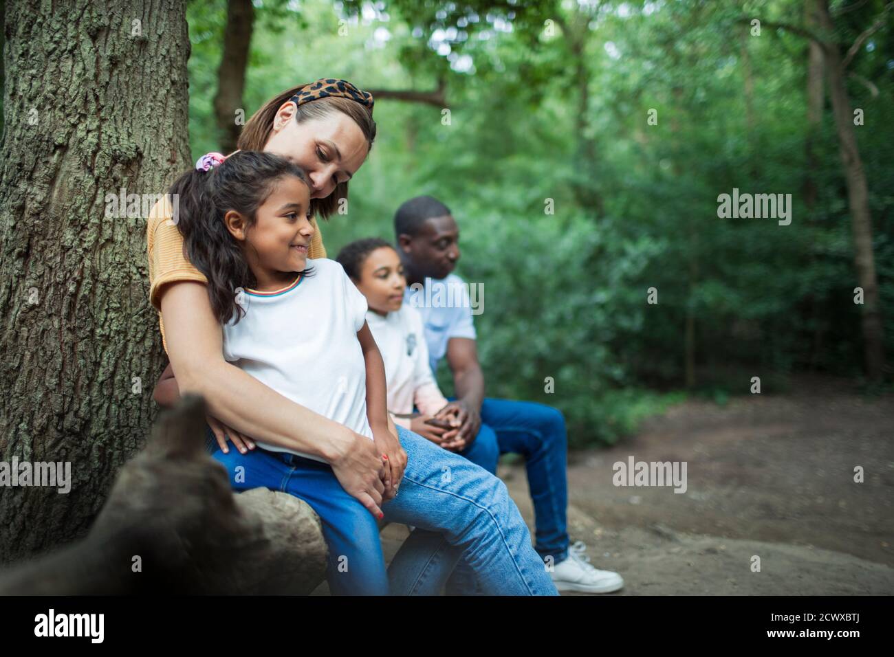 Happy family resting on hike in woods Stock Photo