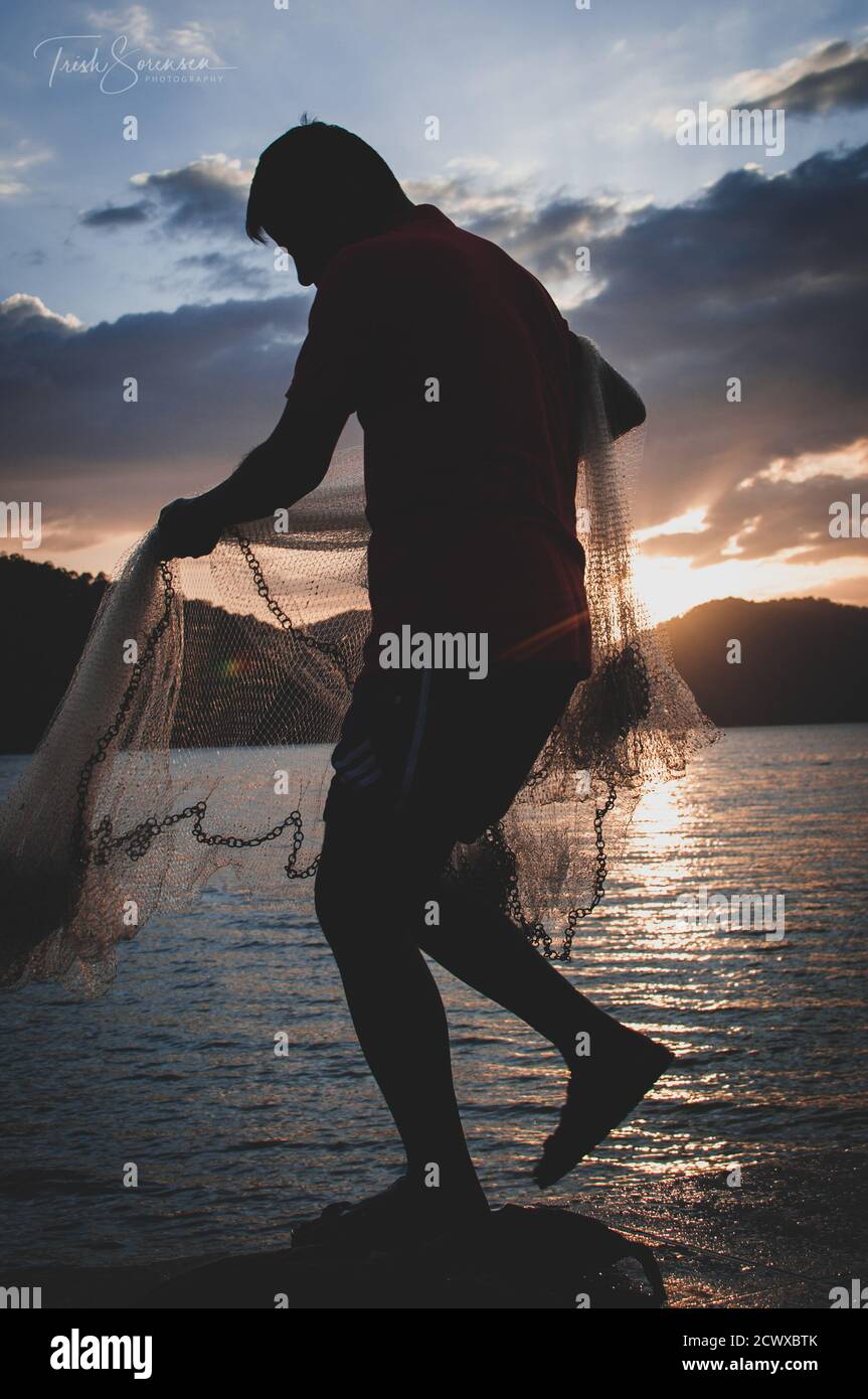 Fisherman and the sunset Stock Photo - Alamy