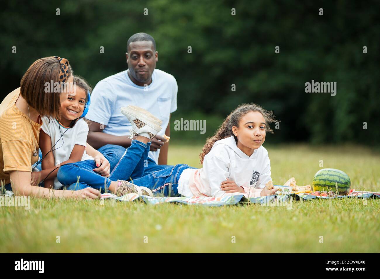 Family relaxing and enjoying picnic in park Stock Photo