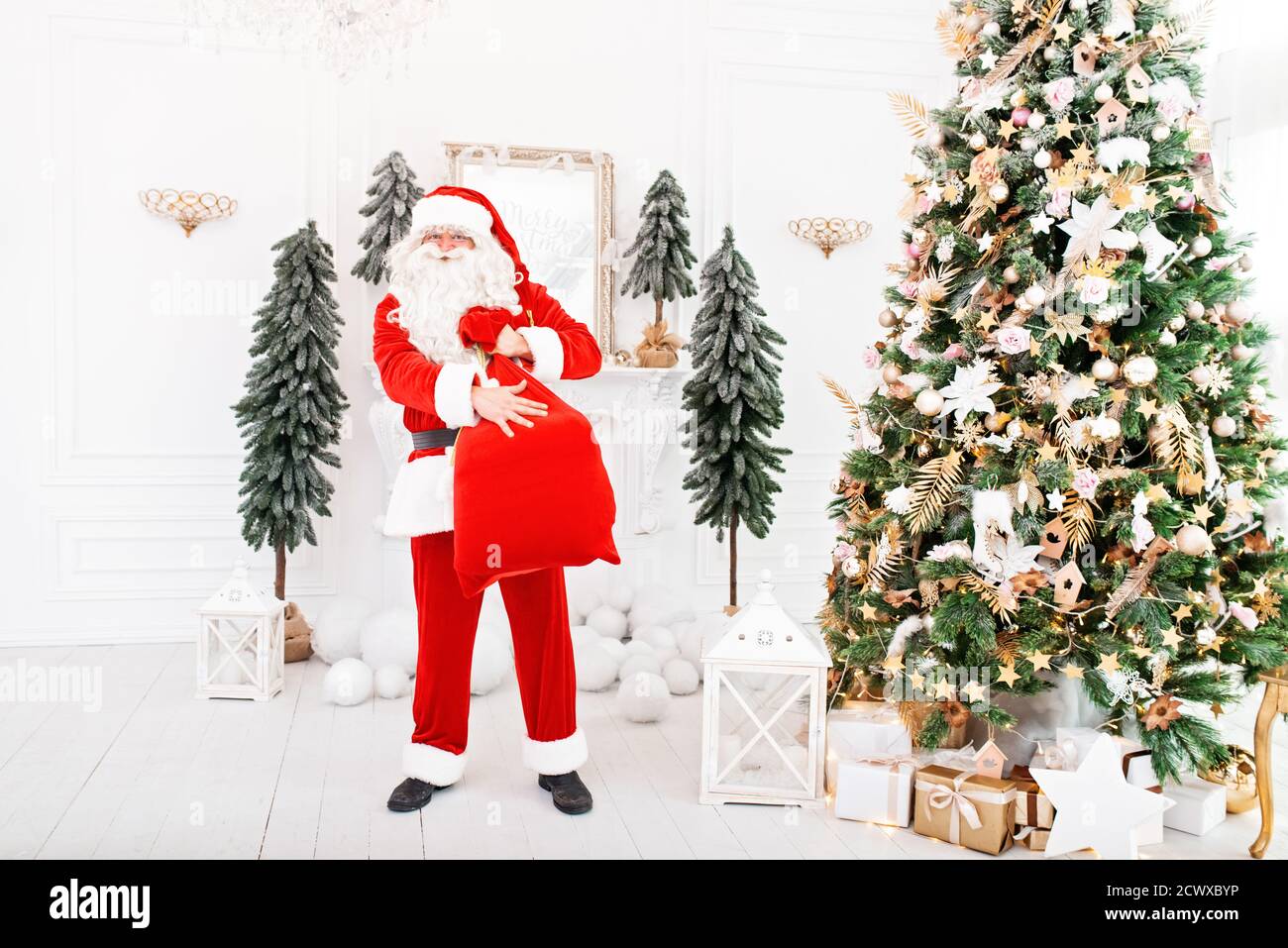 Happy Santa Claus carrying gifts to children Stock Photo - Alamy
