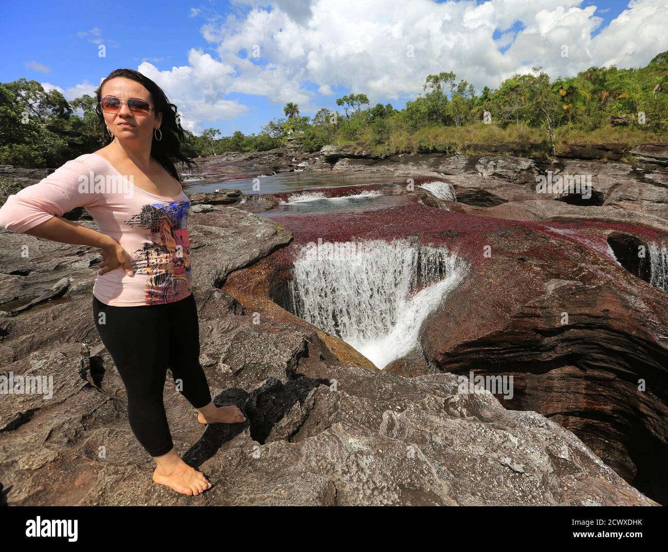 An eco-tourist stands close to a stone hole in Cano Cristales in the Sierra  de La Macarena National Park in Meta province November 24, 2013. The park  is located in the south-east