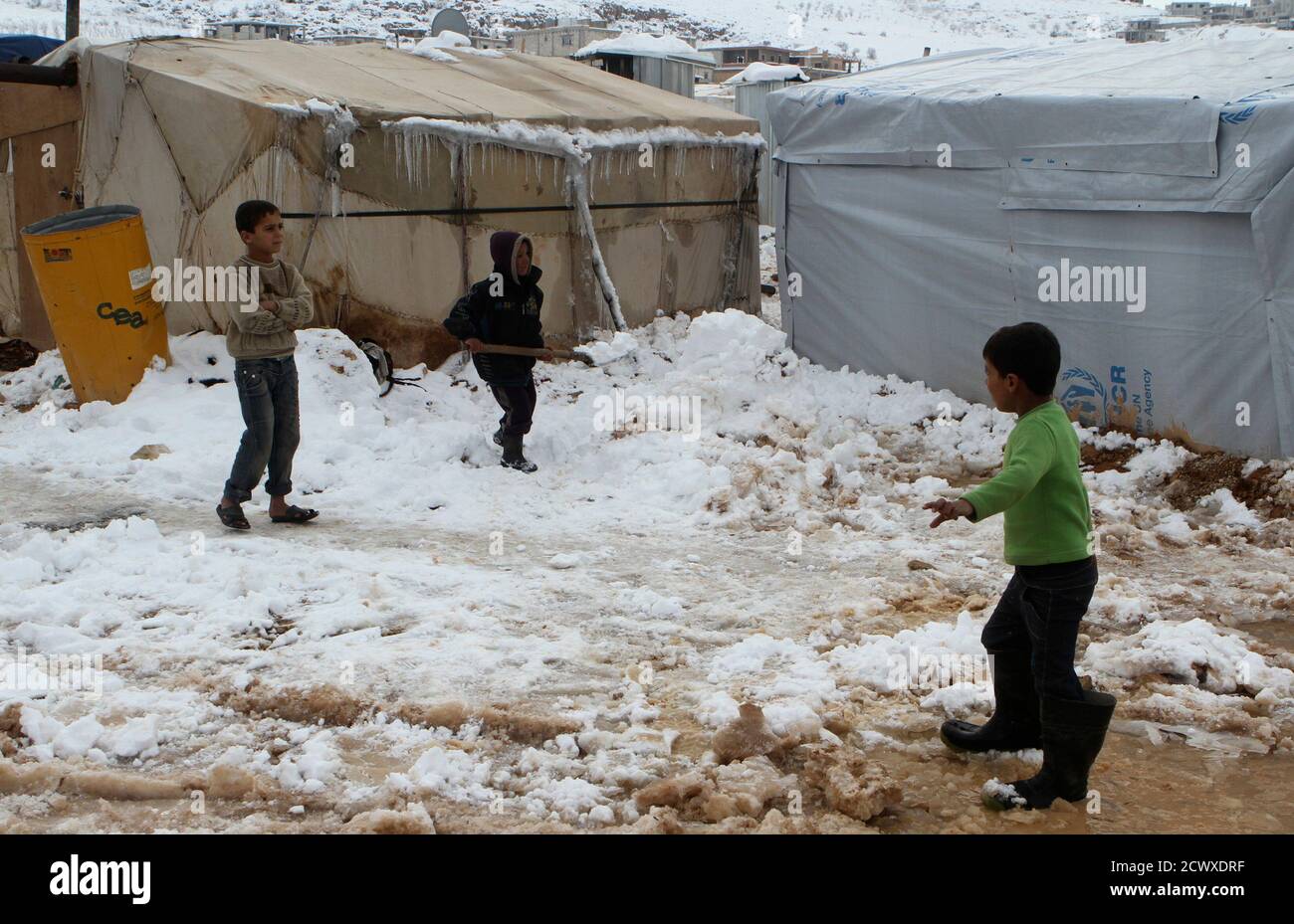 A Syrian refugee child shovels snow outside tent Aarsal town in Lebanon's eastern Bekaa December 13, 2013. A powerful winter storm sweeping the eastern Mediterranean this week causing mayhem