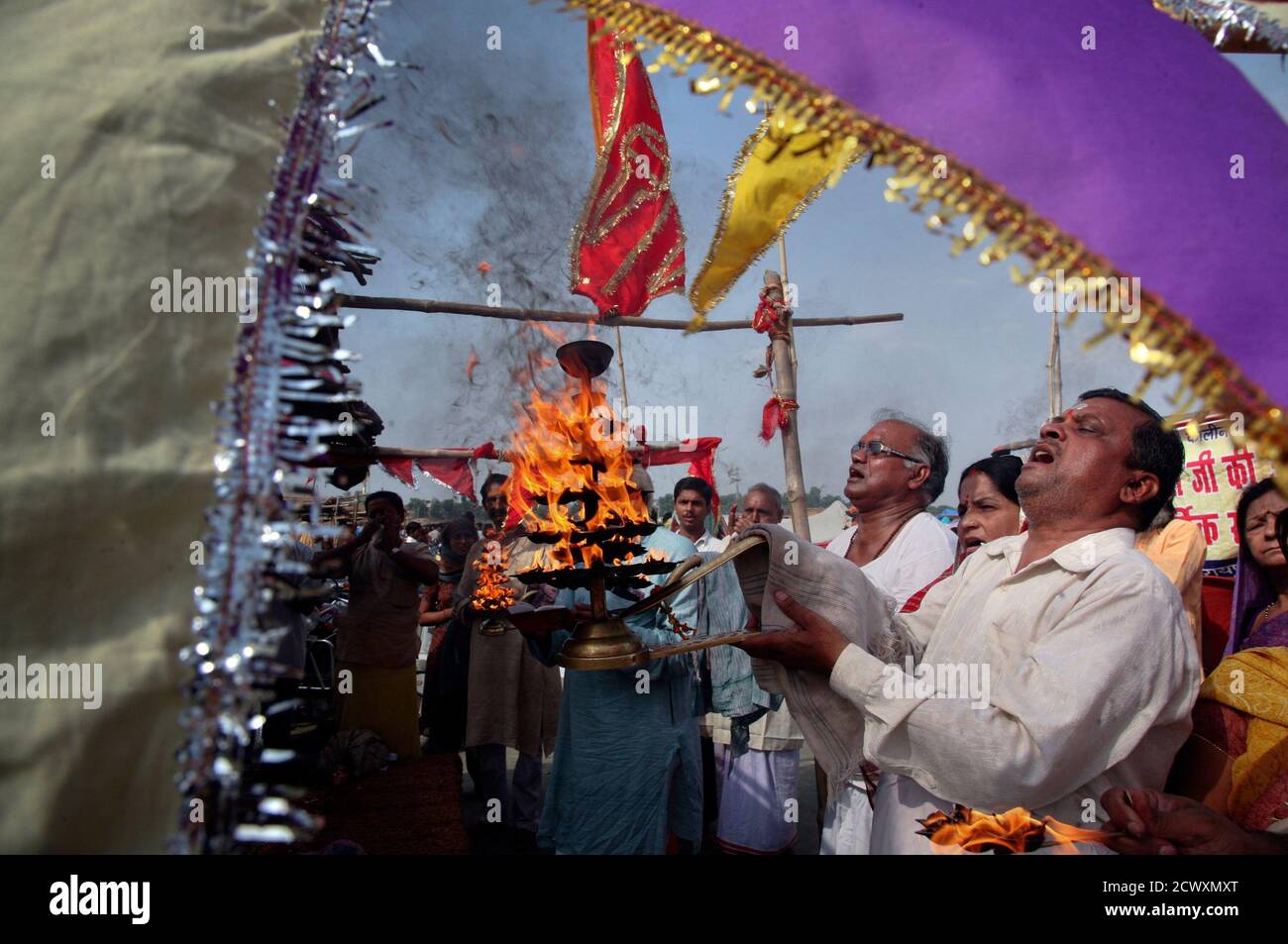 Hindu Devotees Wave Traditional Oil Lamps As They Perform Prayers On The Banks Of River Ganges