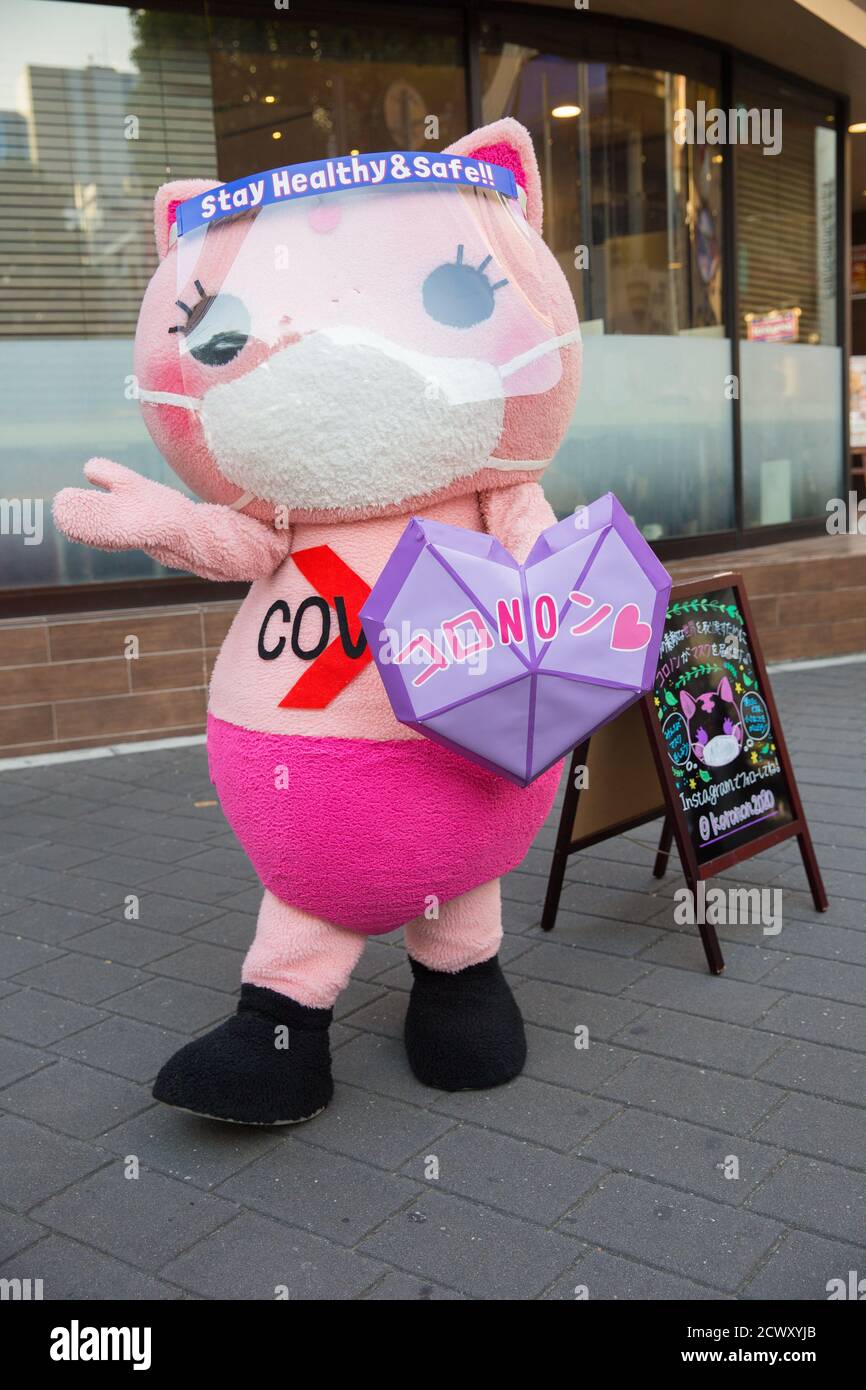 Koronon, a Japanese anti-coronavirus cat mascot raises awareness about the Corona virus (Covid-19) in Ikebukuro, Tokyo.Koronon, a Japanese anti-coronavirus cat mascot who hands out disposable face masks and raises awareness about the coronavirus (Covid-19) waves at pedestrians in Ikebukuro, Tokyo. Koronon can also be booked to visit schools and companies to share its message about hygiene and other measures to fight Covid-19. Stock Photo