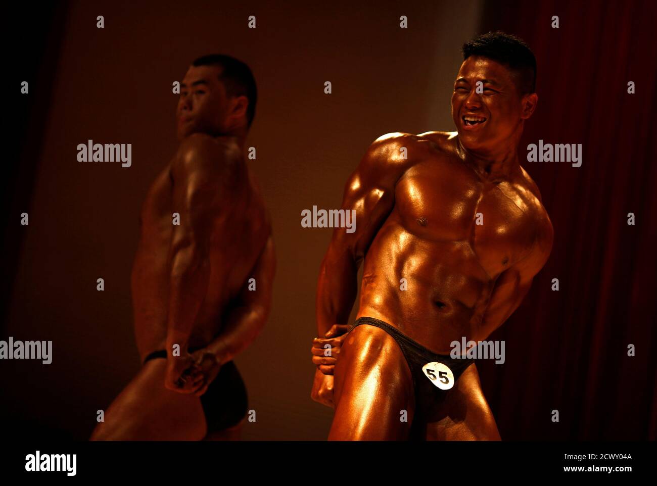 Participants compete in a bodybuilding competition in Shaoxing, Zhejiang province April 20, 2013. Amateur male and female bodybuilders from clubs around Shaoxing city competed in a one-day event to promote the sport. Categories range from 'Mr. Fitness man' to 'Grand Old man' -  for male participants over fifty years old. Every contestant to take first prize received a medal, diploma and 1000 rmb ($160) in cash.  REUTERS/Carlos Barria  (CHINA - Tags: SPORT SOCIETY) Stock Photo