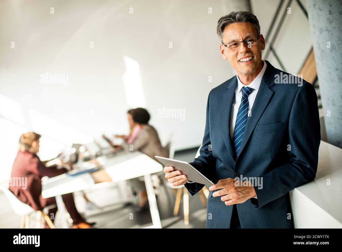 Handsome businessman using his digital tablet in the office Stock Photo ...