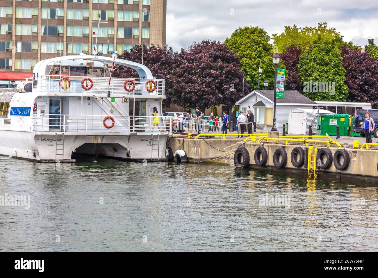 Kingston waterfront, Ontario, Canada, August 2014 - Passengers line up to board a cruise boat docked by the quayside Stock Photo