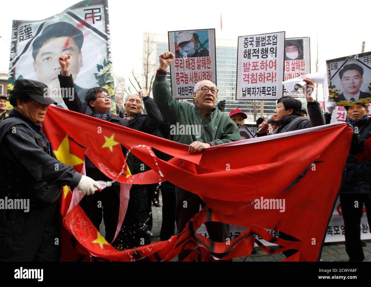 South Korean protesters chant slogans after slashing a defaced Chinese flag  during an anti-China protest near the Chinese embassy in Seoul December 14,  2011. South Korea said on Wednesday it had asked