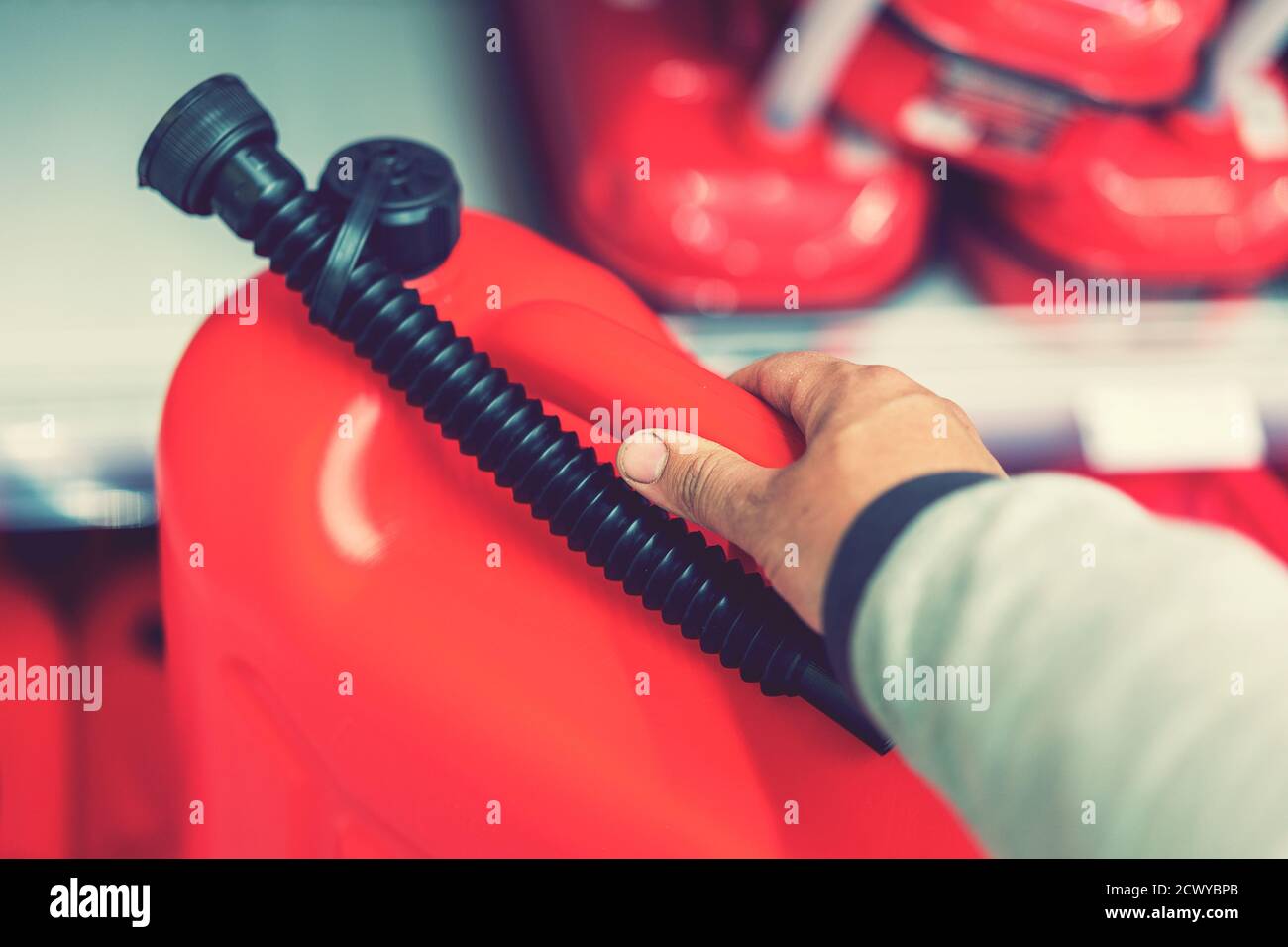 Red canister in the hands of a man. Concept of empty tank, problems