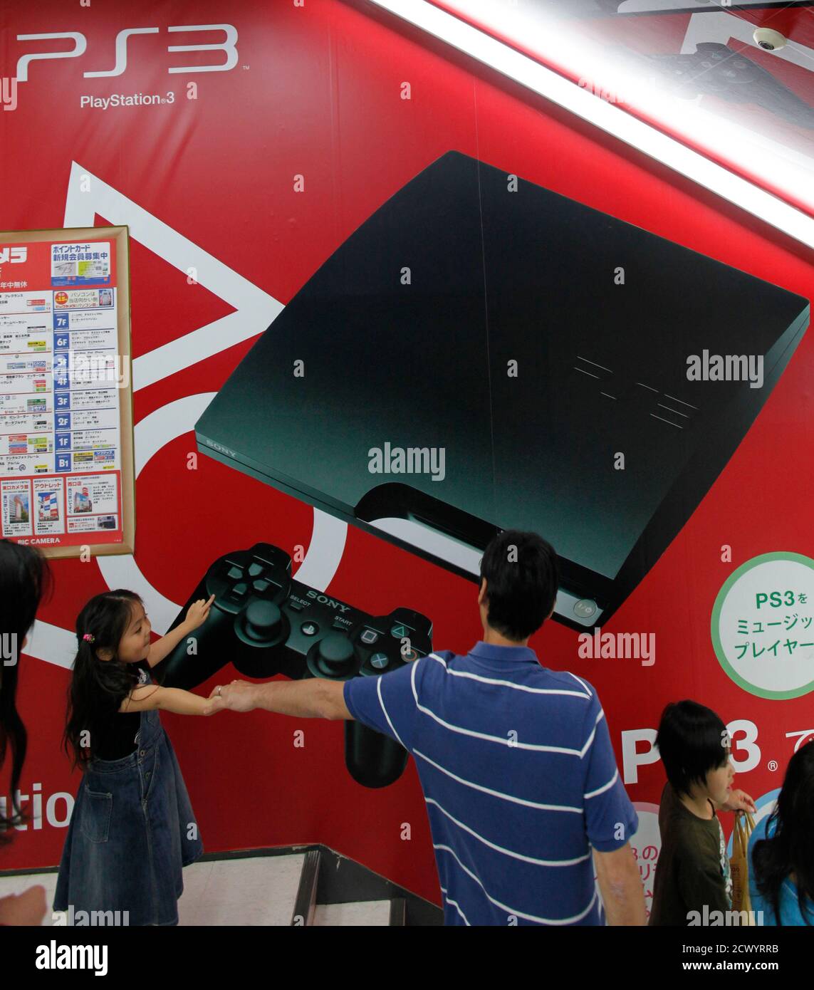 A girl points to an advertisement for the Sony PlayStation at an electronic  shop in Tokyo May 15, 2011. Sony said it had begun restoration of its PlayStation  Network games service on