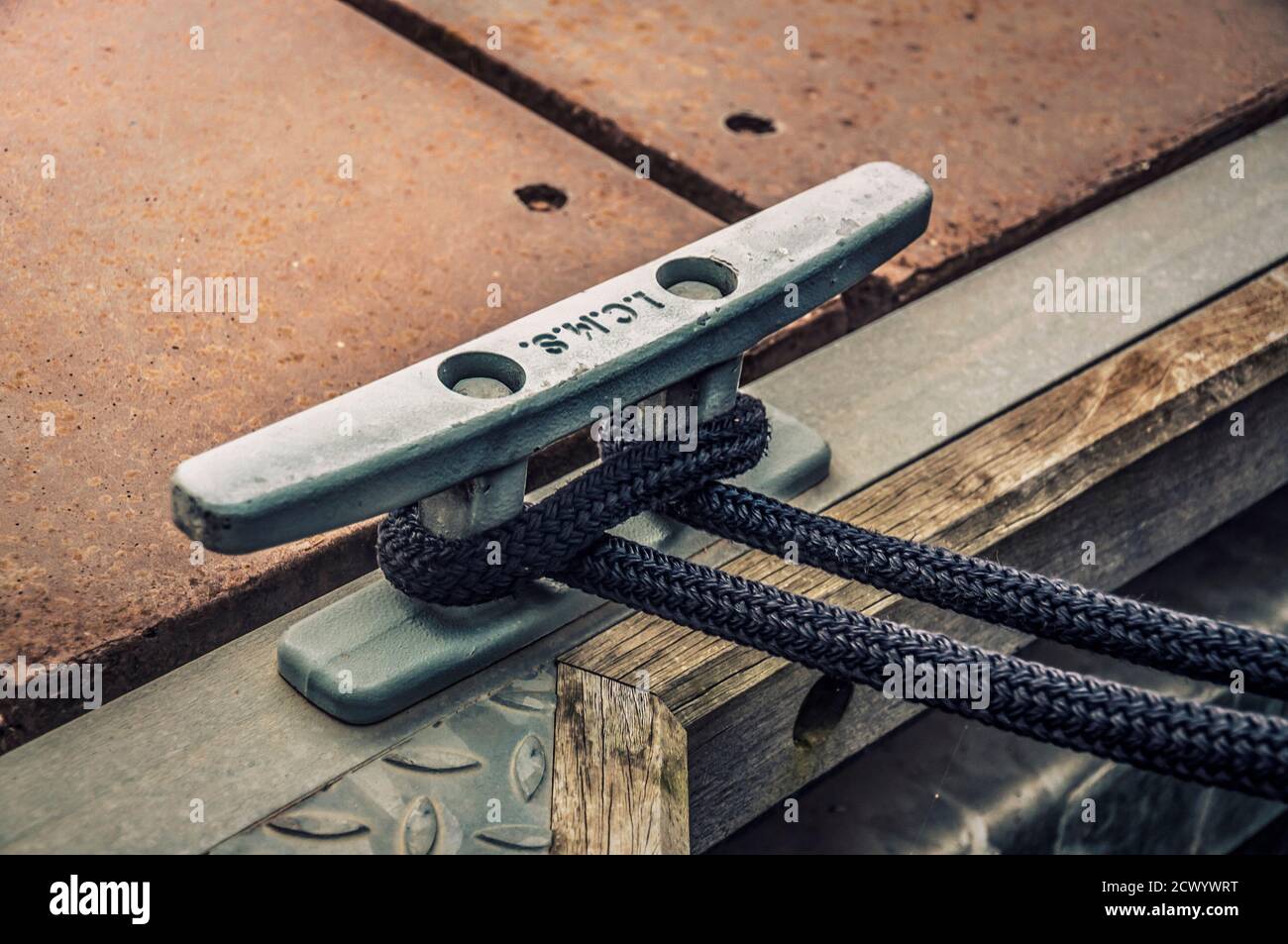 Close up of the dock cleat with a rope tied around it. Connection visual concept as boat tied and linked to the pontoon. Stock Photo