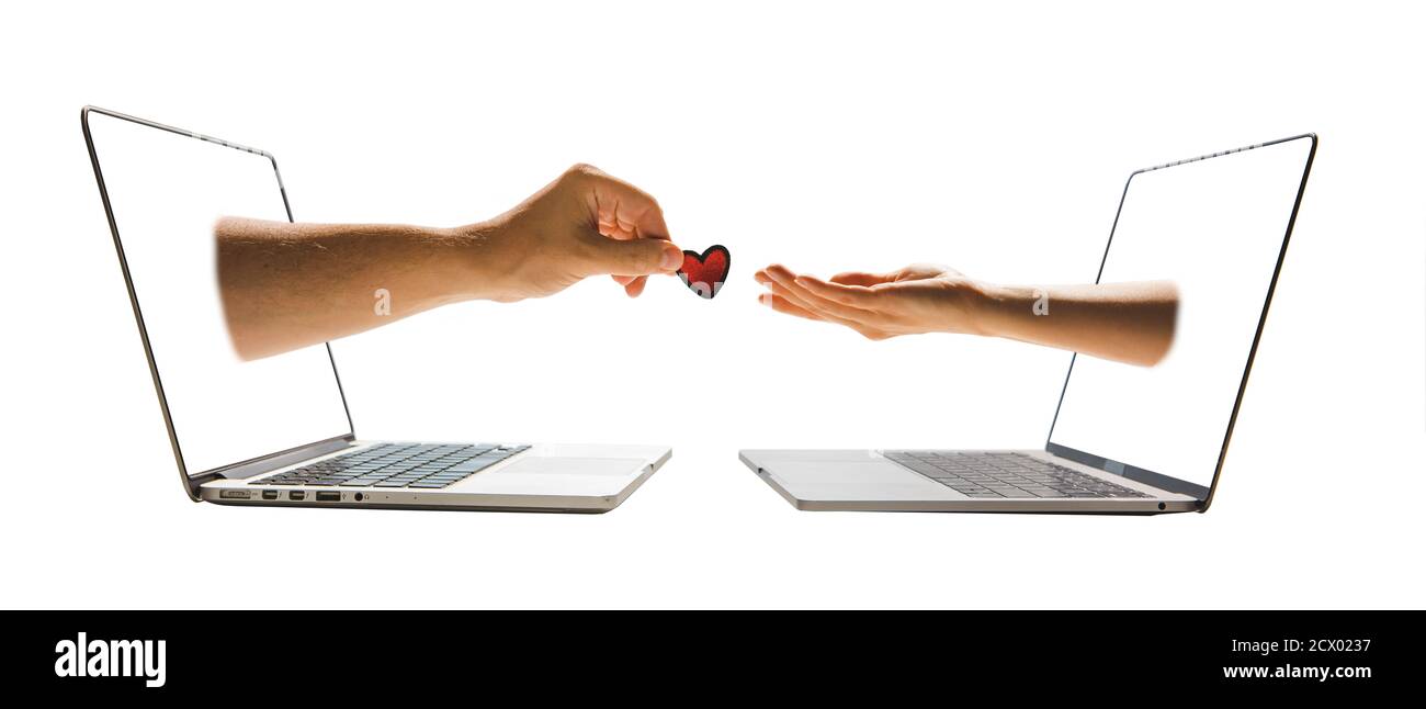 online dating concept two hands stick out of laptop screen Stock Photo
