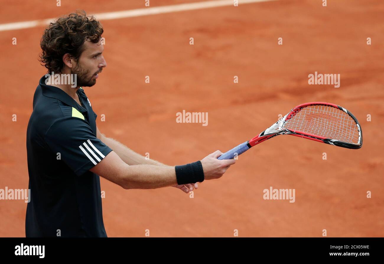 Ernests Gulbis of Latvia holds a broken racket after he smashed it during  his men's singles match against Roger Federer of Switzerland at the French  Open tennis tournament at the Roland Garros