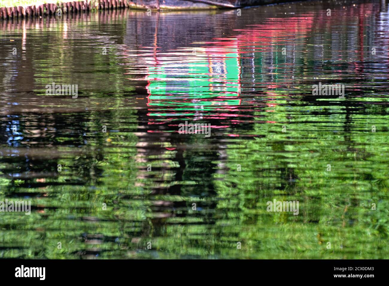 Abstract shapes created by the reflections of brightly painted narrow boat in water Stock Photo