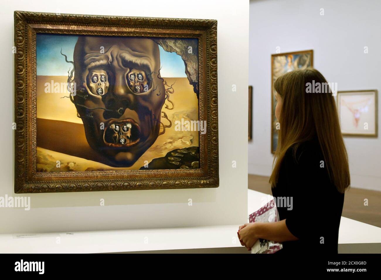 A visitor looks at the painting 'Le visage de la guerre 1940' (The face of  the War) by Spanish artist Salvador Dali (1904-1989) during the press visit  of the exhibition "Dali" at