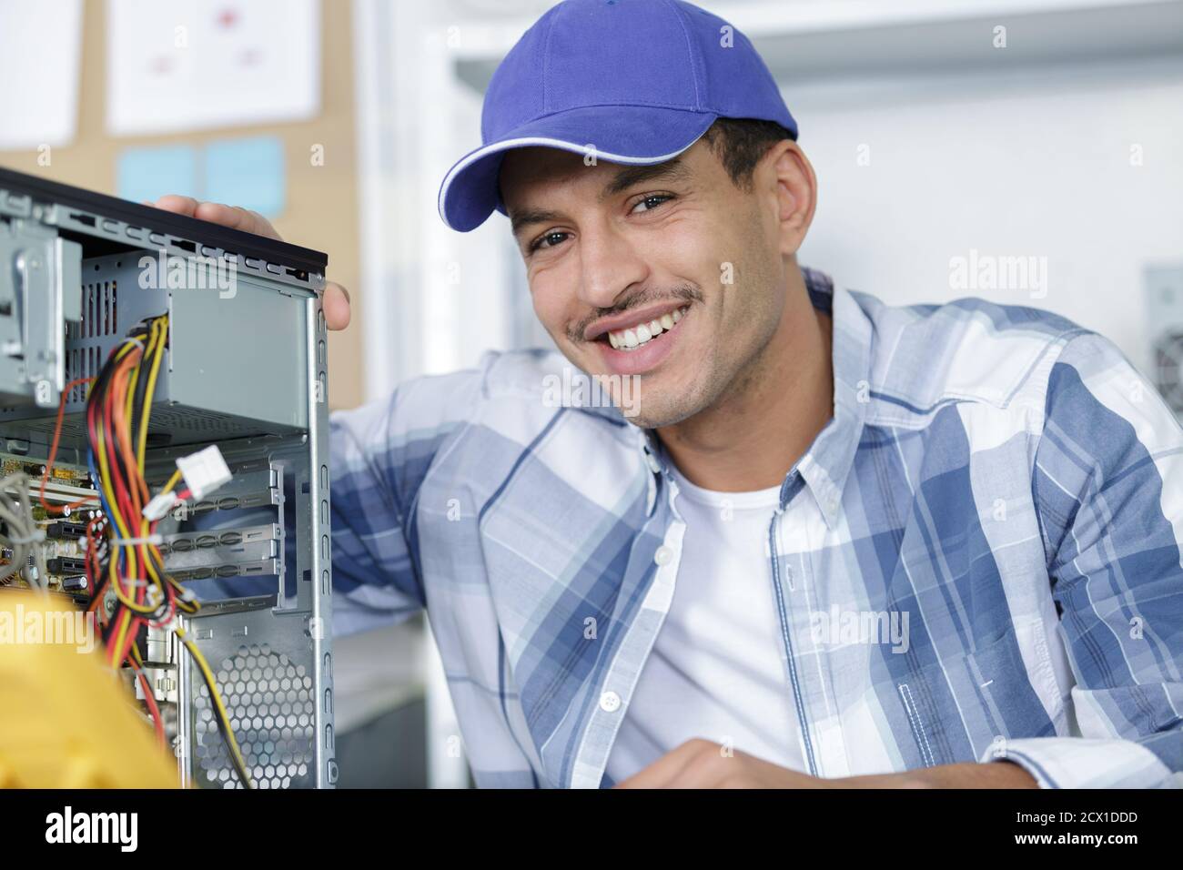 smiling man using multimeter while fixing pc Stock Photo