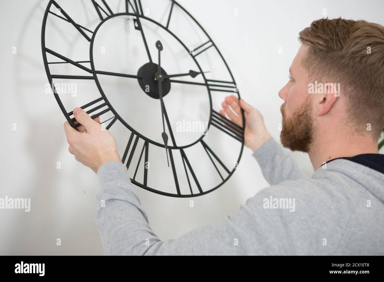 man changing time on beautiful wall clock Stock Photo Alamy