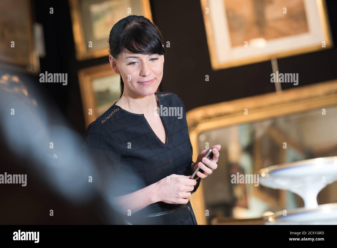 female antique collector looking at the display Stock Photo Alamy