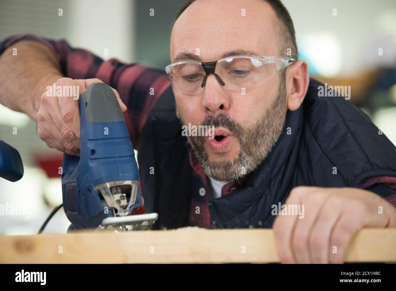 man blowing off sawdust and carefully inspecting Stock Photo Alamy