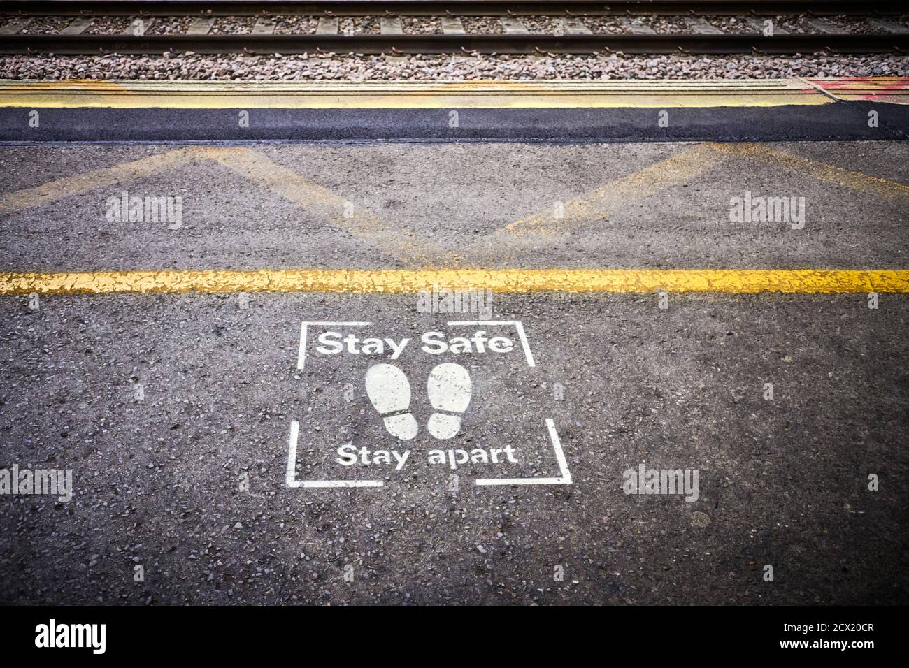 Stay safe, stay apart stencil at the platform edge on Milton Keynes railway station Stock Photo