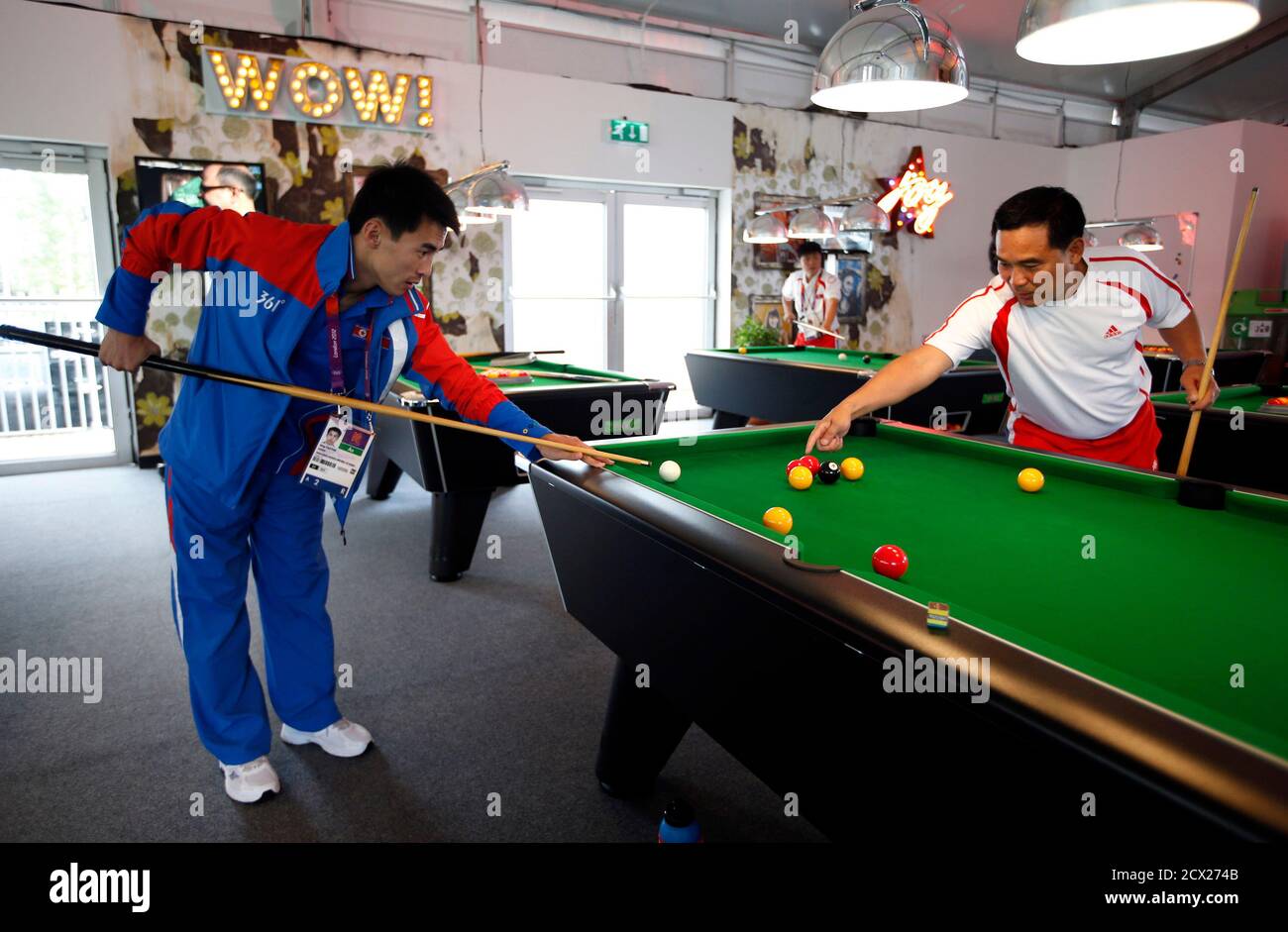 Boxer Pak Jong Chol of North Korea (L) plays pool at the Athletes' Village at the Olympic Park in London,  July 19, 2012.    REUTERS/Jae C. Hong/Pool (BRITAIN - Tags: SPORT OLYMPICS BOXING) Stock Photo