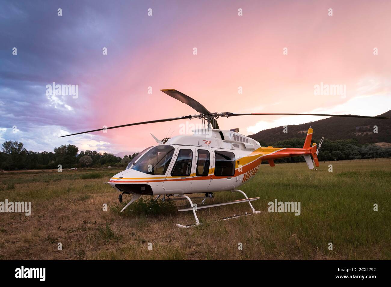 Helicopter on field against cloudy sky during sunset Stock Photo